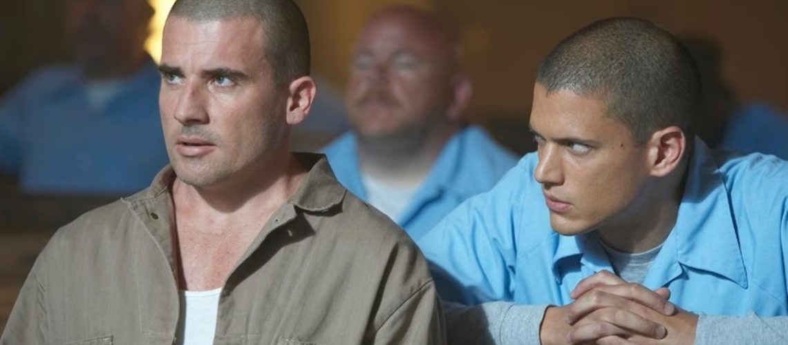 Inmate Michael Scofield (right, played by Wentworth Miller), dressed in blue prison attire, looks intently at his brother (left, Dominic Purcell) as they quietly hatch their escape plan in "Prison Break".