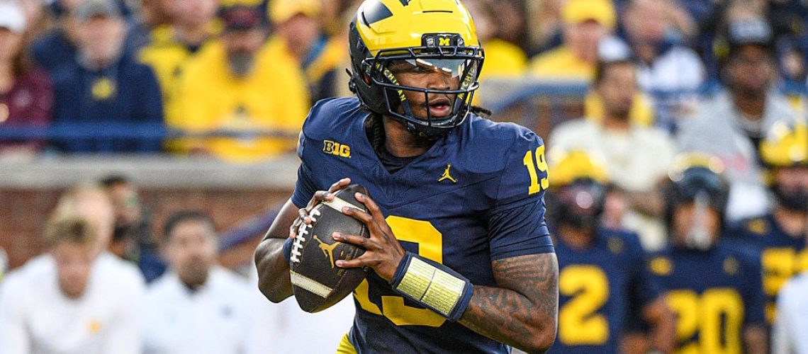 Bryce Underwood of the Michigan Wolverines preparing to throw the ball downfield during a college football game.