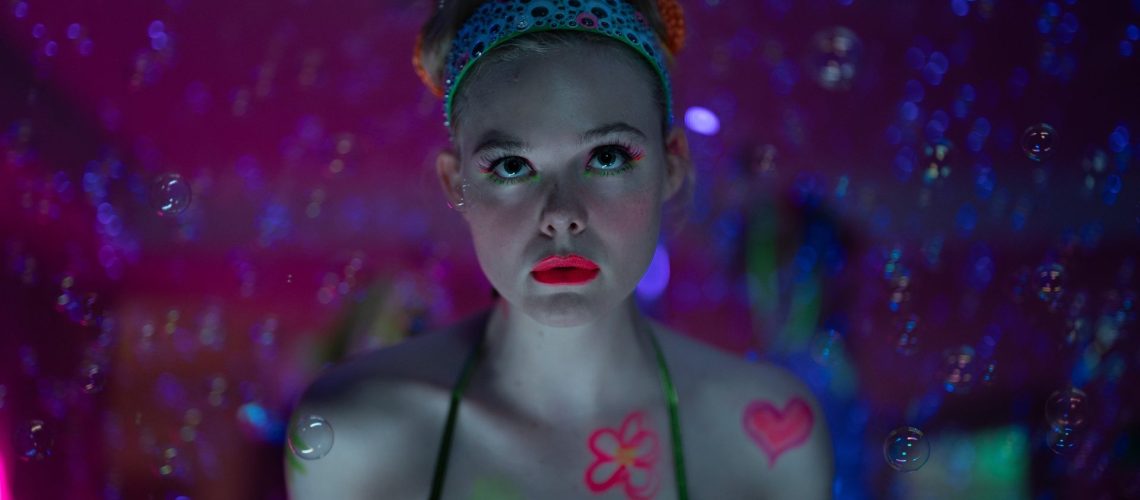 A close up of Elle Fanning wearing bright red lipstick in a scene from Apple TV's 'Margo’s Got Money Trouble'.