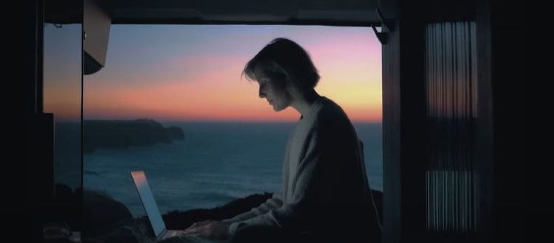 Asus promotional video for its new laptop showing a woman working on a computer overlooking the sea