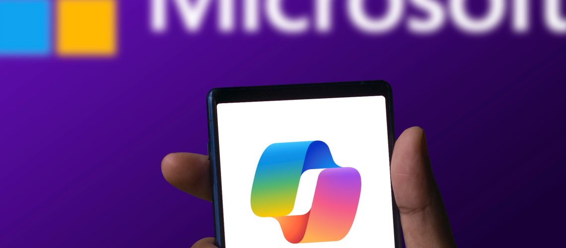 Microsoft Copilot app running on a phone with Microsoft logo in background