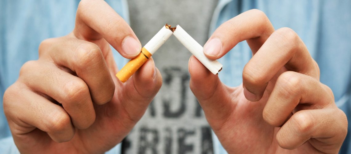 Close up of mans hands snapping a cigarette
