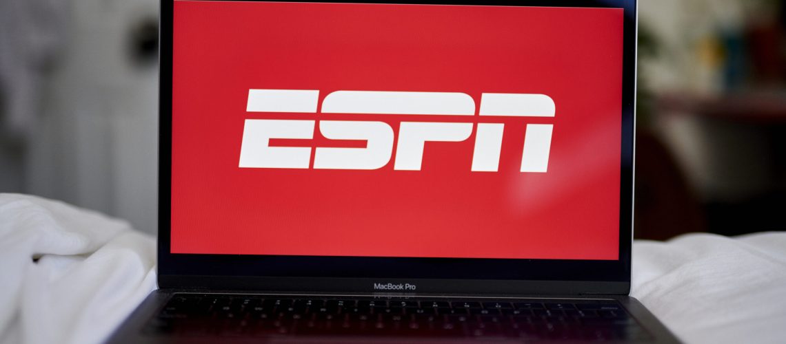 the ESPN logo is on a laptop open on a bed