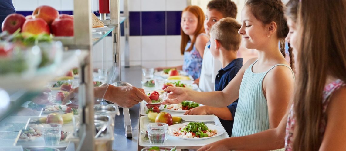 Group of children as elementary students at buffet line,