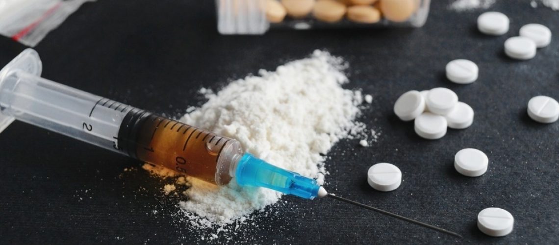Syringe, pills and powder on black background, closeup. Hard drugs