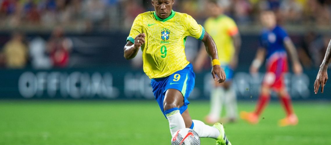 Endrick dribbles the ball for Brazil in the standard yellow shirt and blue shorts first strip.