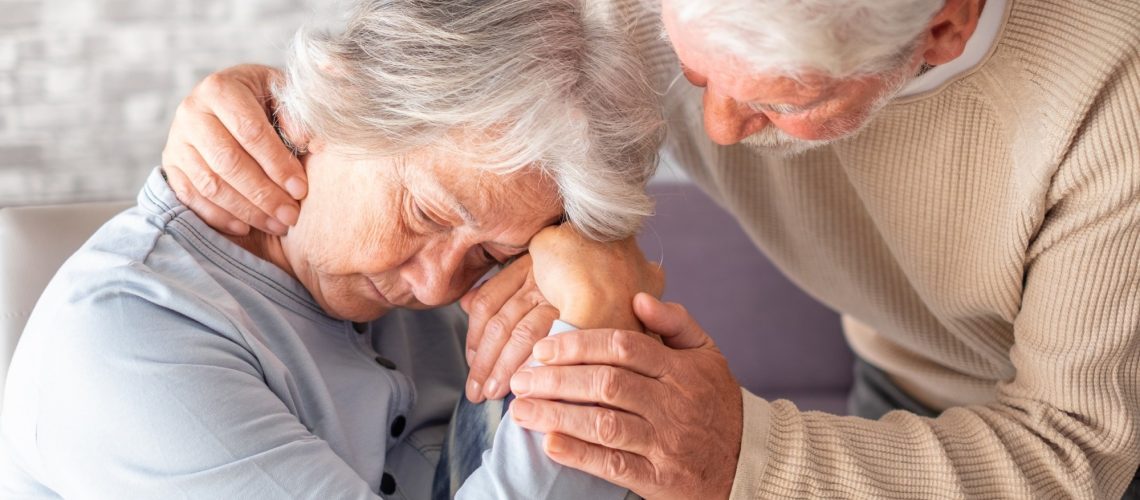 Senior man comforting his depressed illness wife
