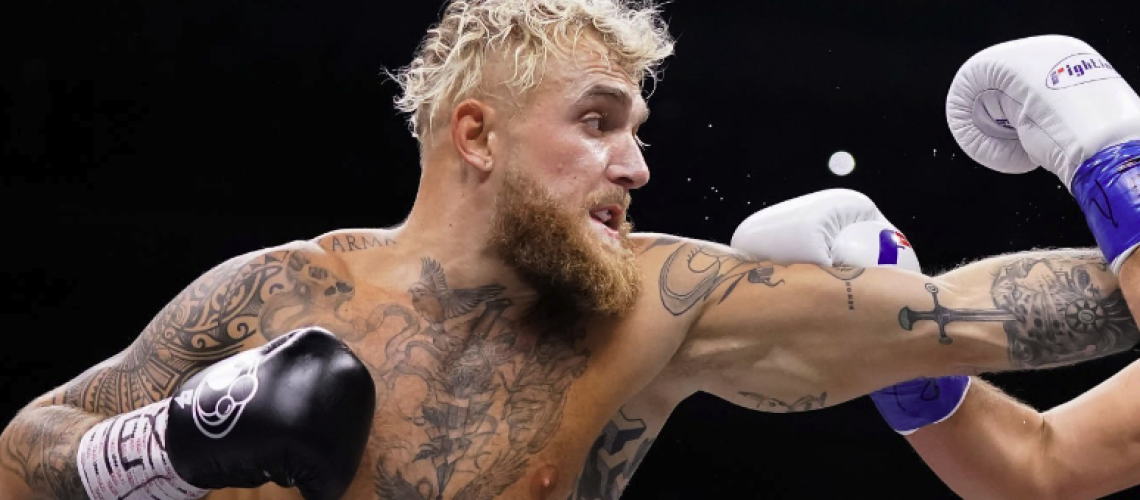 Jake Paul, with blonde hair and black gloves, throws a left ahead of the Jake Paul vs Mike Perry live stream