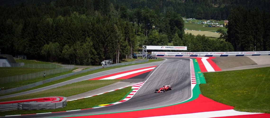 A Ferrari Formula One car sweeps around a corner at the Austrian Grand Prix at the Red Bull Ring in Spielberg