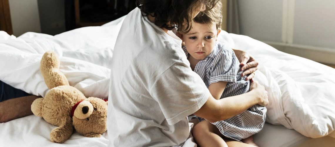 Mother hug and consoling the little boy from nightmare