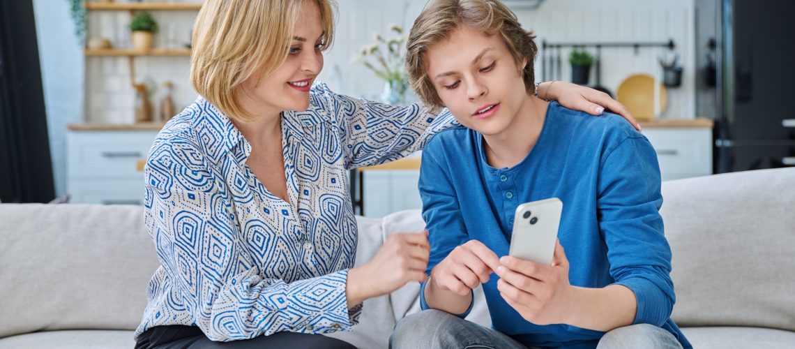 Parent with teenager looking at phone
