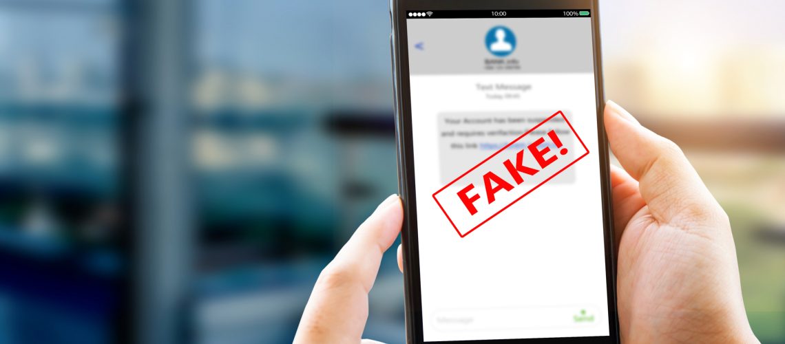 A fake text message on a smartphone being held by both hands
