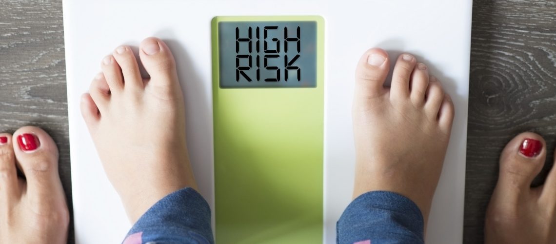 child’s feet on weight scale under the supervision of his mother