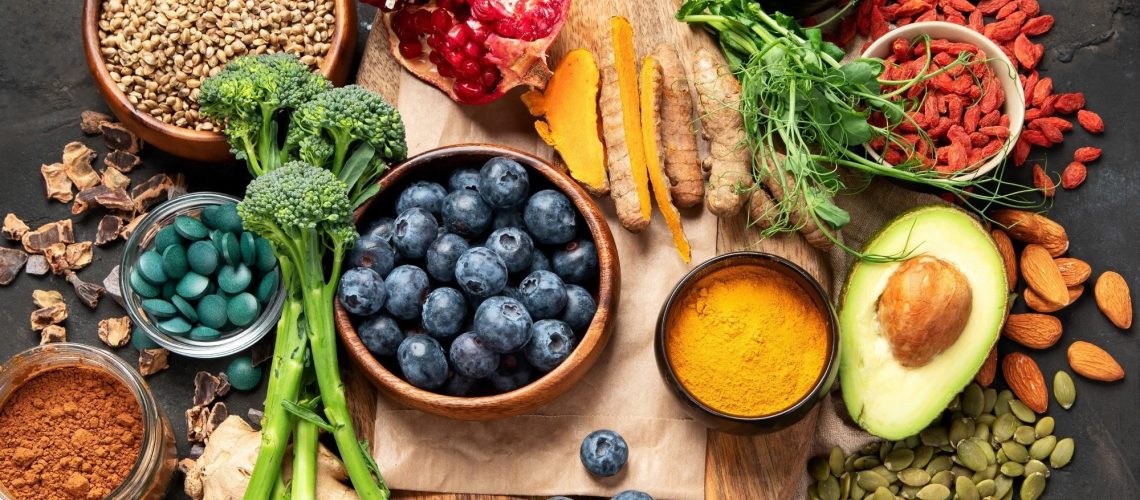 high flavanol food selection including blueberries, and brocolli on dark background. Superfood assortment. Top view,.