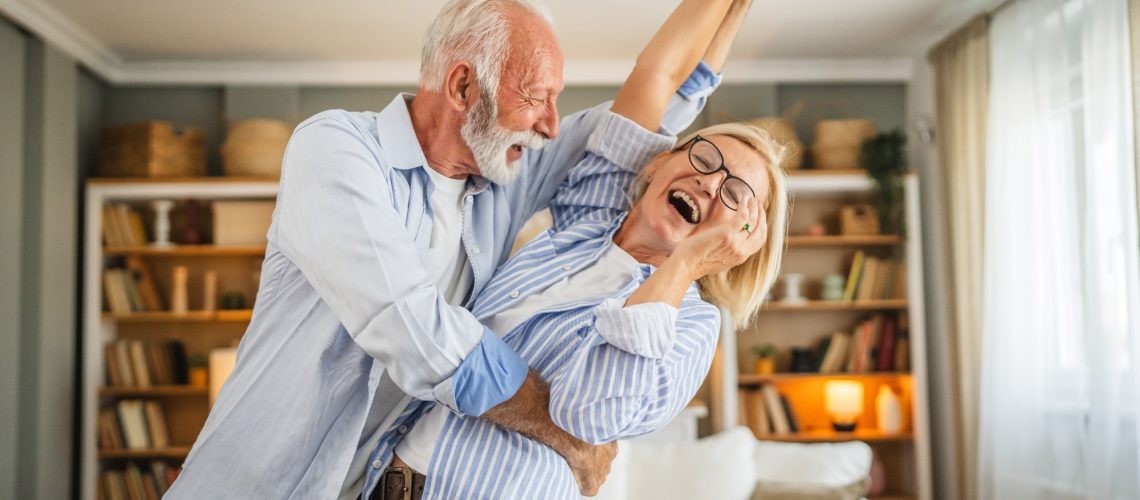 Senior active couple husband and wife dancing.