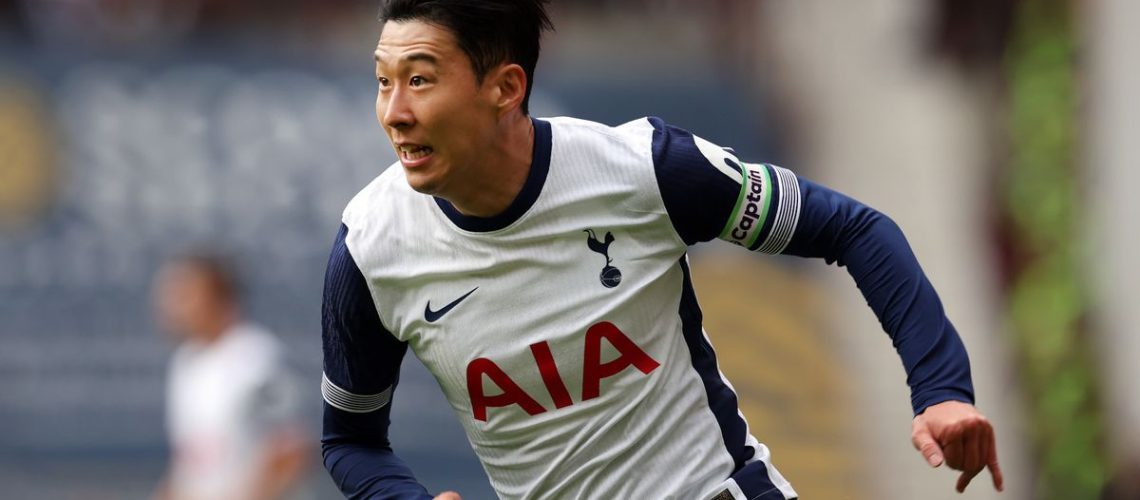 Son Heung-Min running at high speed in the Tottenham navy blue and white strip.