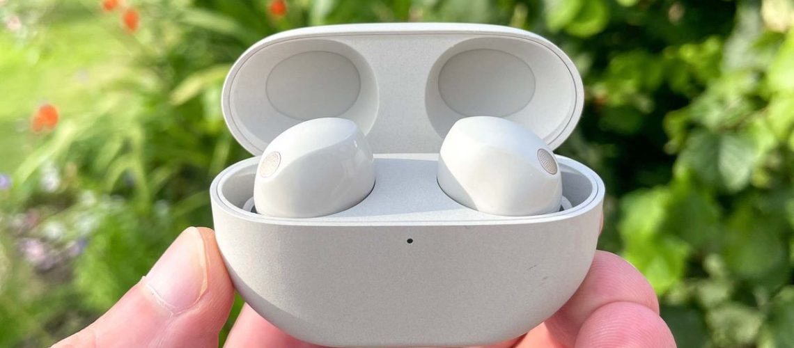 Sony WF-1000XM5 hero shot with earbuds in white charging case