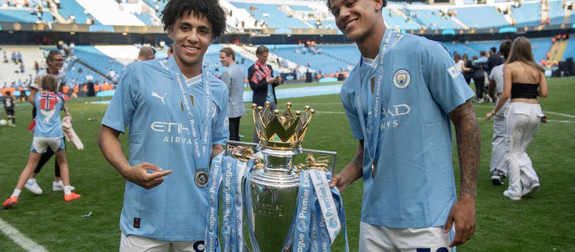 Rico Lewis and Oscar Bobb with the Premier League trophy