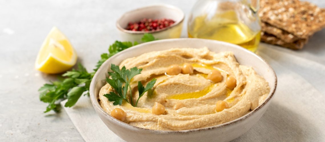 Fresh hummus with chickpea olive oil and lemon with multigrain crackers