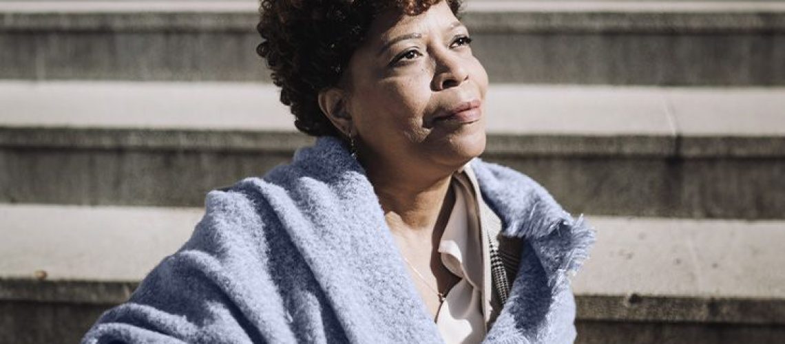 photo of older black woman in blue shawl gazing into the distance