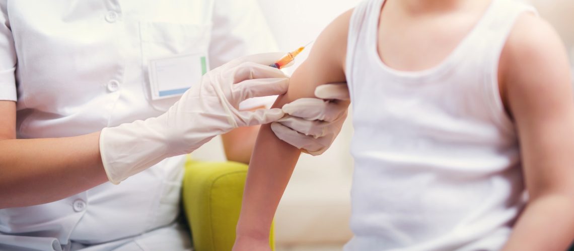 Pediatrician makes vaccination to small boy