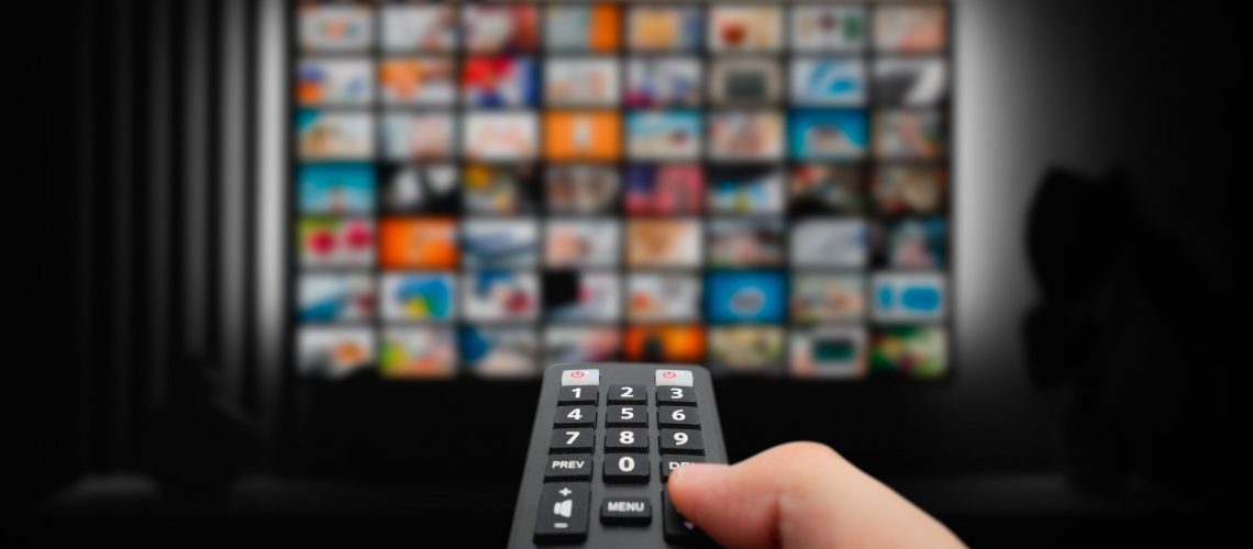Man watching TV with remote control in hand