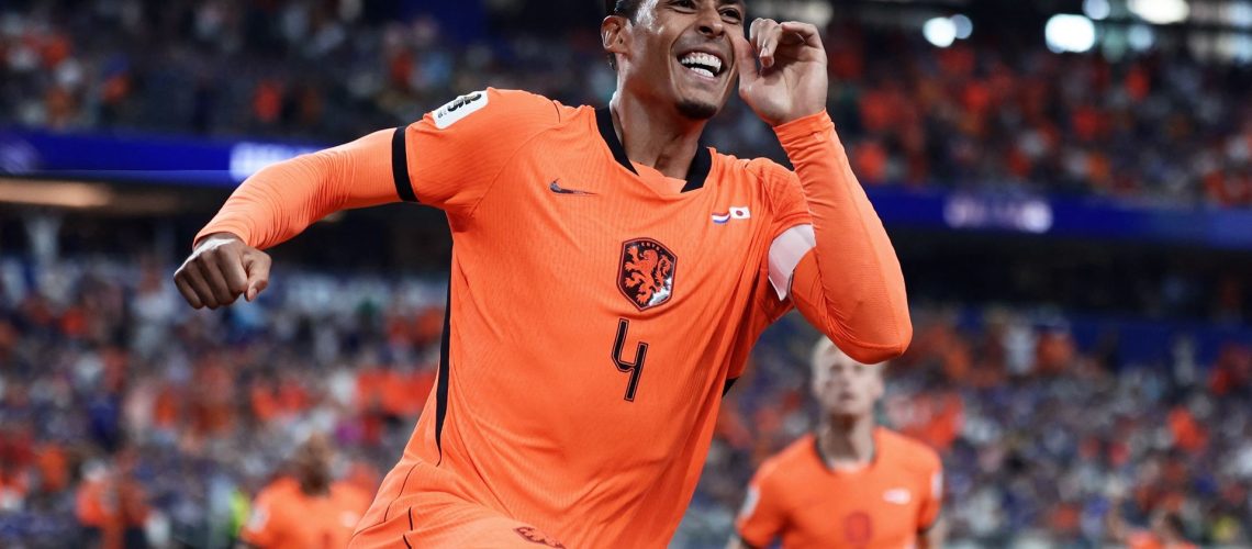 Netherlands' defender Virgil van Dijk, wearing orange, touches his ear in celebration after scoring the opening goal during the 2026 World Cup Group F match with Japan.