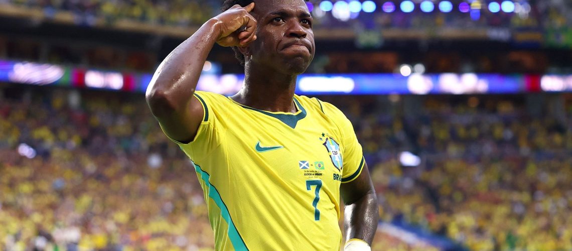 Vinicius Junior #7 of Brazil, wearing yellow shirt, celebrates scoring his team's second goal during the FIFA World Cup 2026, saluting the crowd in a packed stadium