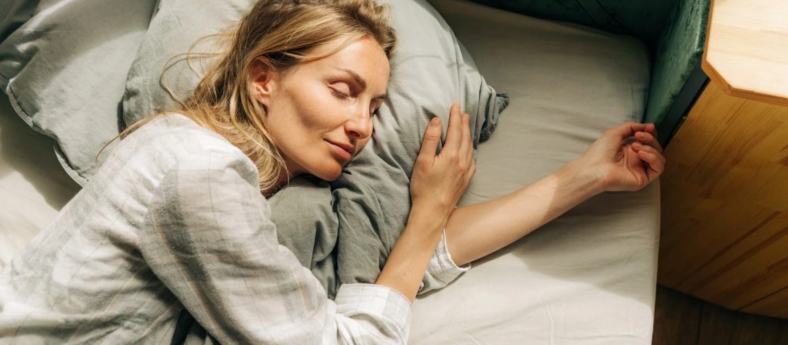 Young caucasian woman is sleeping in her bed