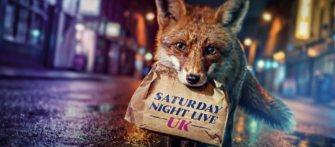 A fox holds a brown paper bag with 'Saturday Night Live' written on it