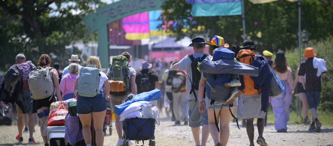 Isle of Wight festival entrance with people carrying their camping gear.