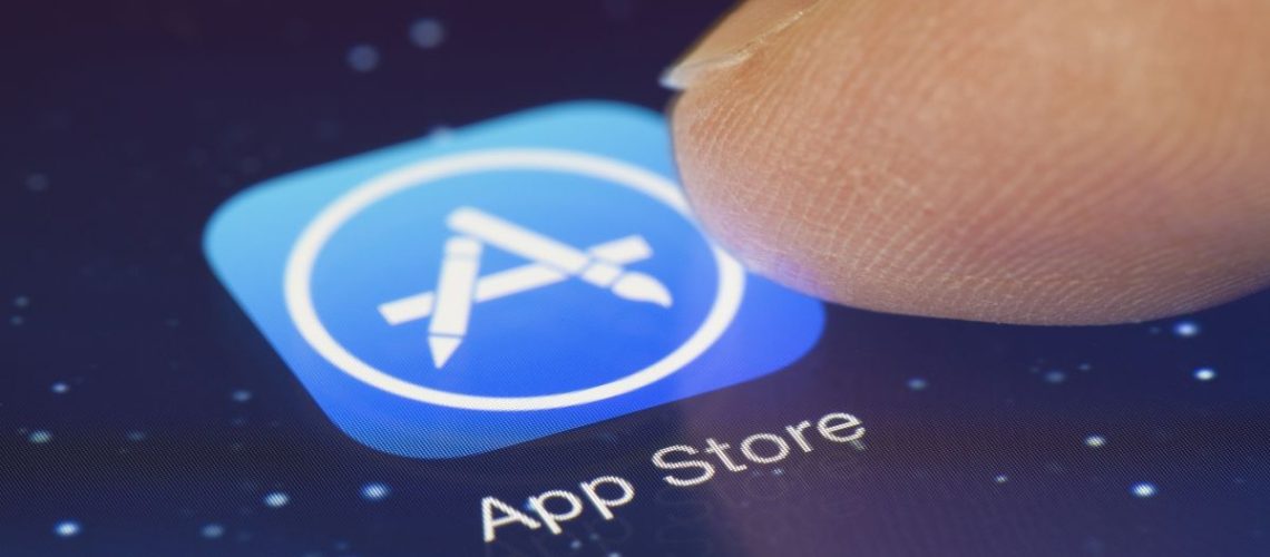 finger about to touch Apple App Store icon on iPhone