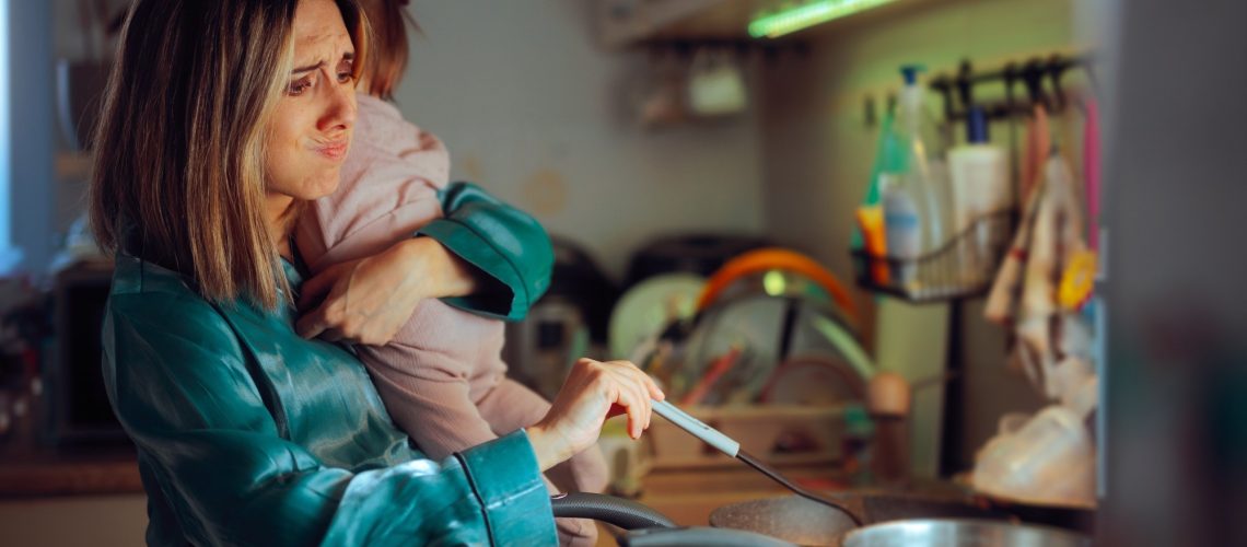 Busy Mom Holds Baby While Preparing Meal in Kitchen