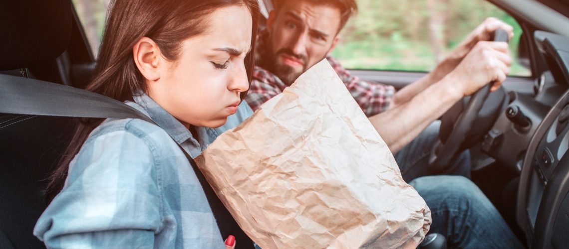 A picture of sick girl holding a bag and trying to vomit into it