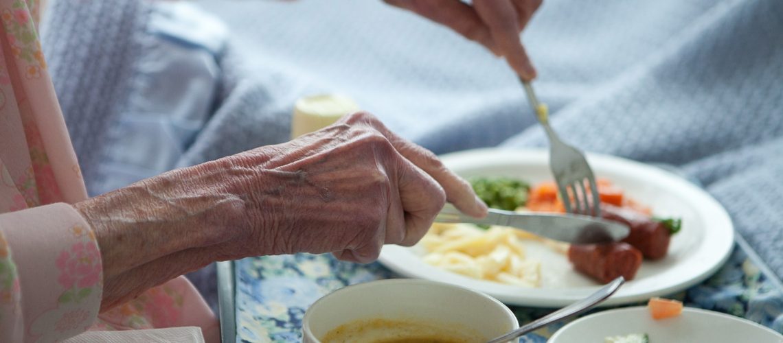 Elderly lady eating healthy lunch in bed.