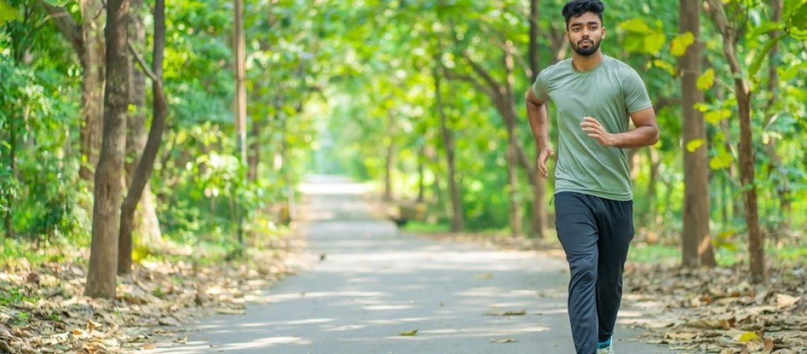 Young man running in the park at morning