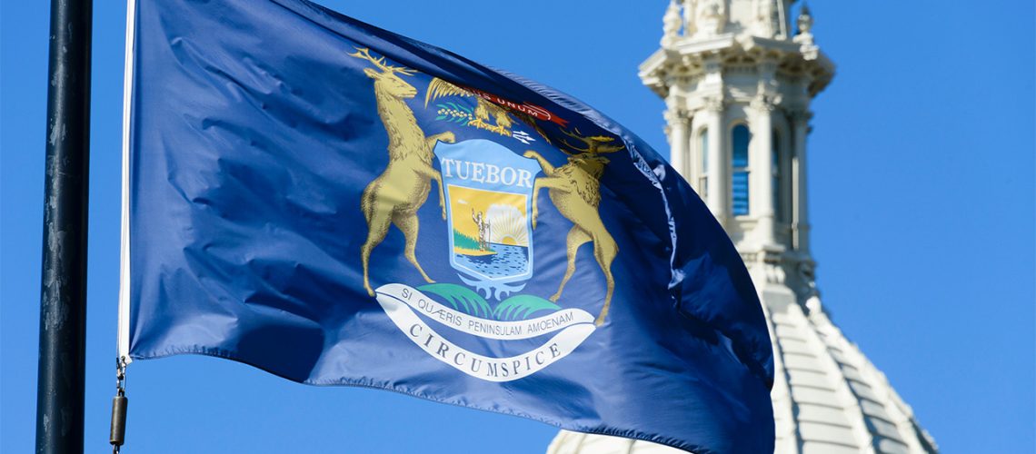 State flag of Michigan flying in front of its Capitol building