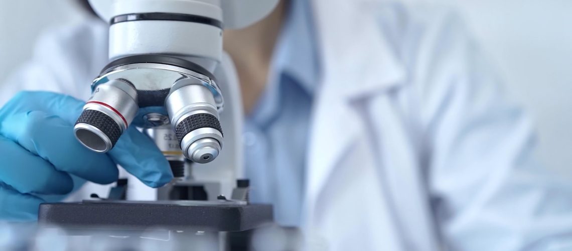 Scientist using microscope in laboratory.