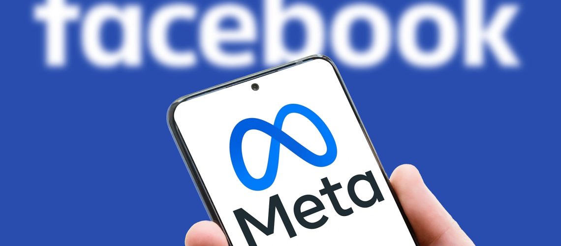 Meta logo on screen of mobile phone on Facebook word background. Facebook after rebranding and changing name to Meta.