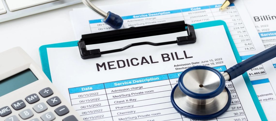 Medical bill concept with calculator and stethoscope on white desk