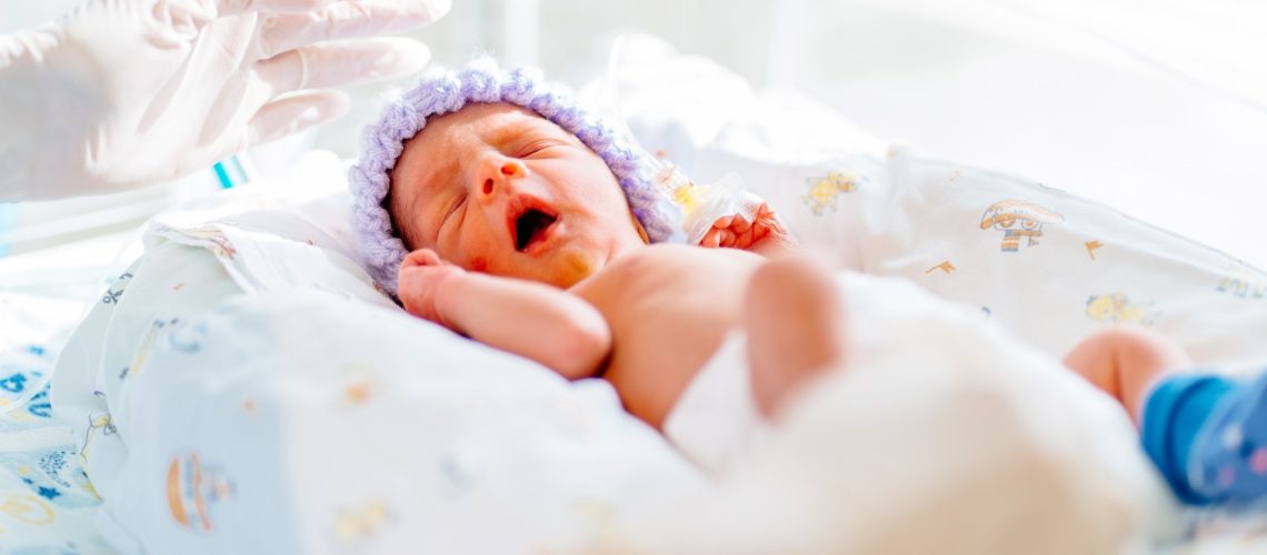 yawning premature born baby in intensive care unit