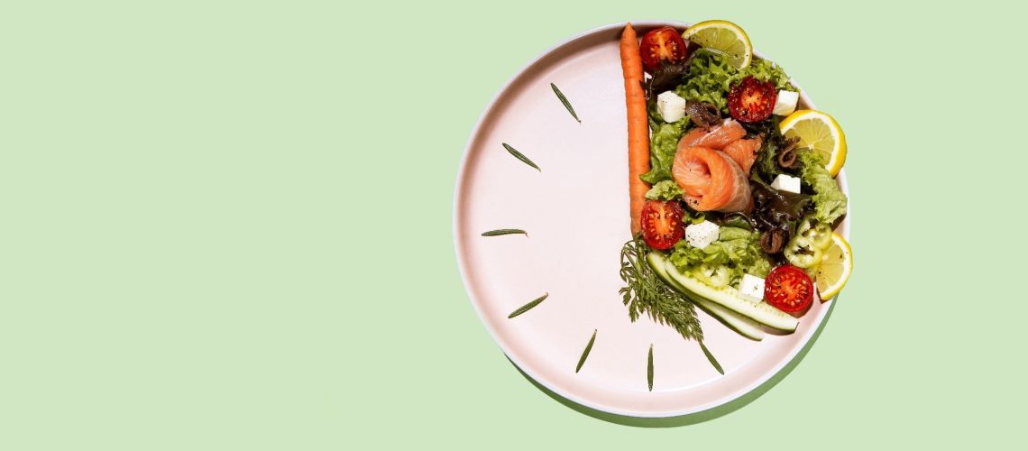 intermittent fasting concept clock dish with vegetables and salmon, fish, salad