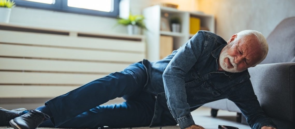 Disabled Senior Man Lying On Carpet