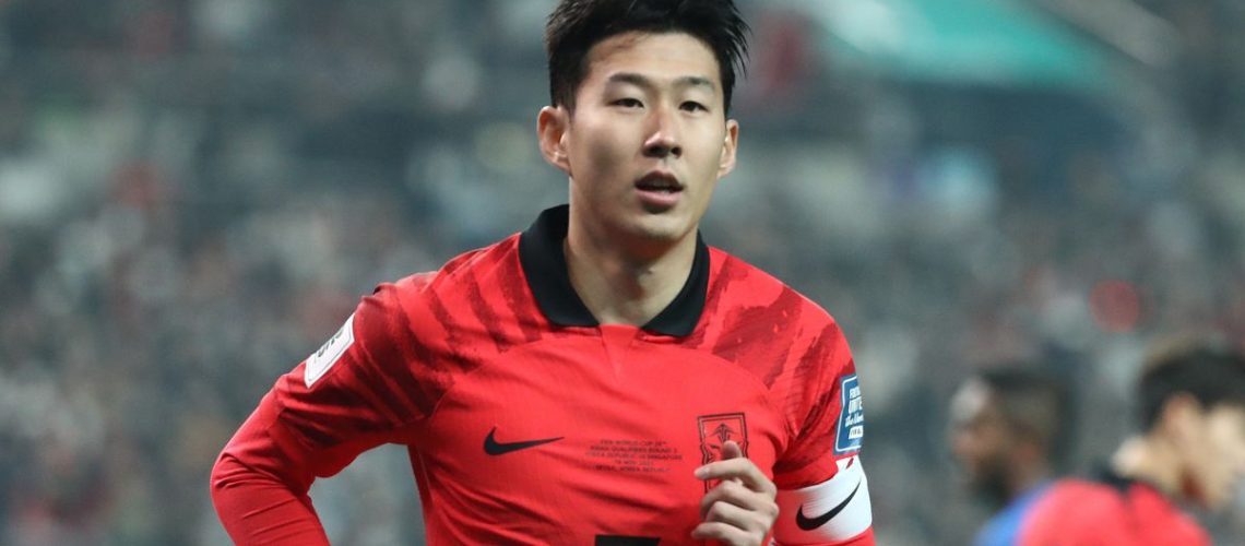 Son Heung-min, wearing a red and black South Korea soccer shirt, warms up for the AFC Asian Cup in Qatar.