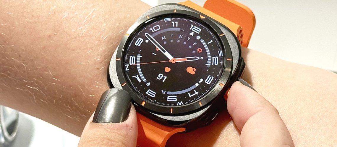 The Samsung Galaxy Watch Ultra on an orange rubber strap worn on the wrist of a user