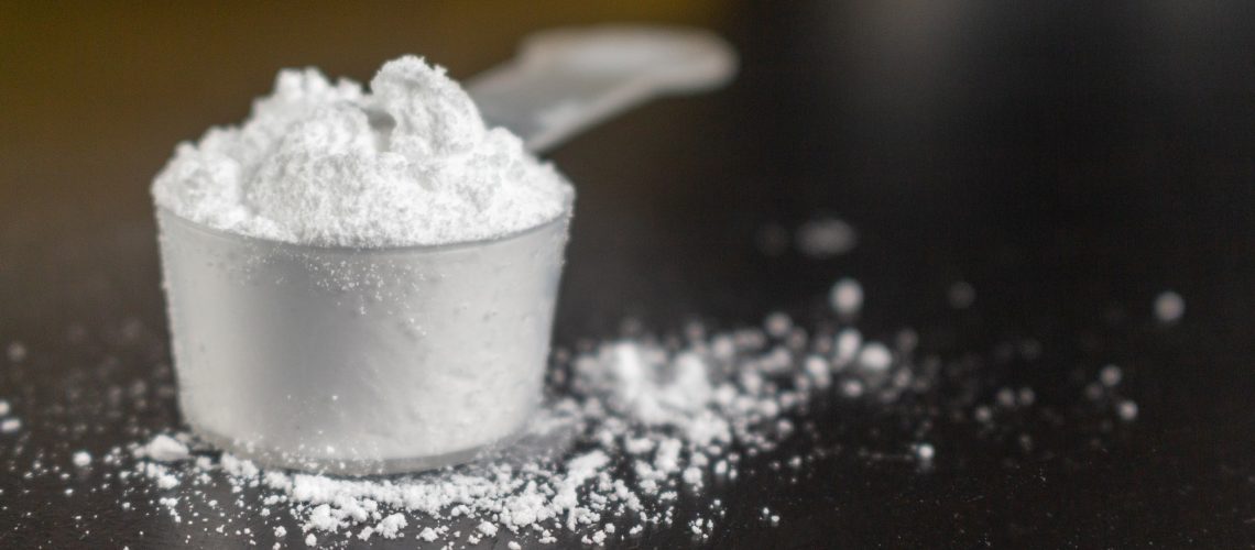 Creatine powder in a measuring scoop