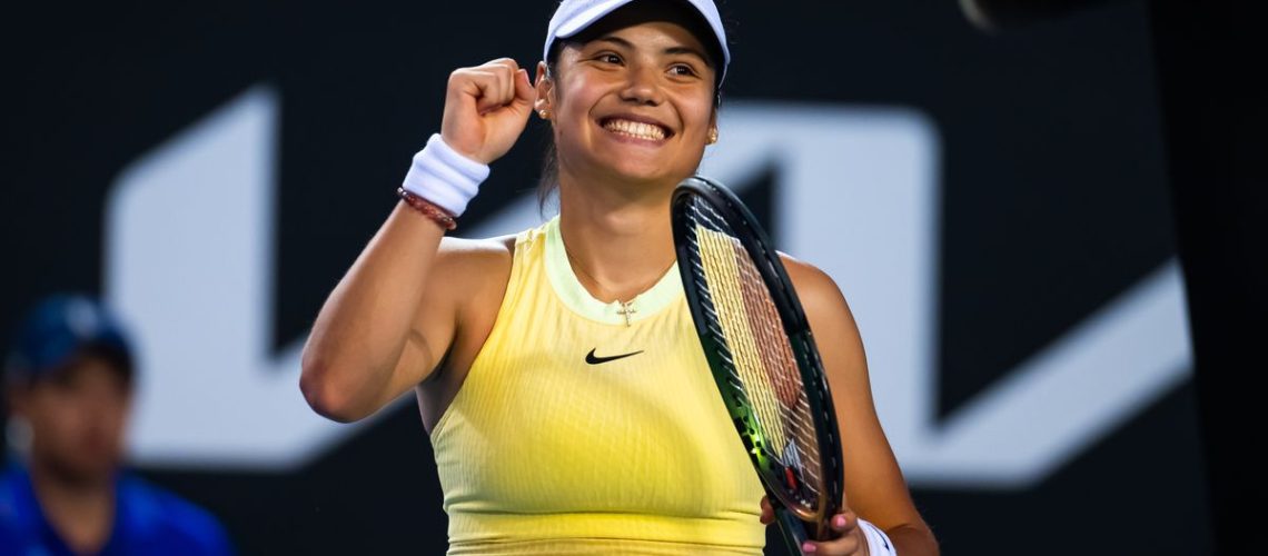 Emma Raducanu, wearing a yellow Nike tennis dress and white visor, pumps her fist prior to the Australian Open 2024 Raducanu vs Wang live stream
