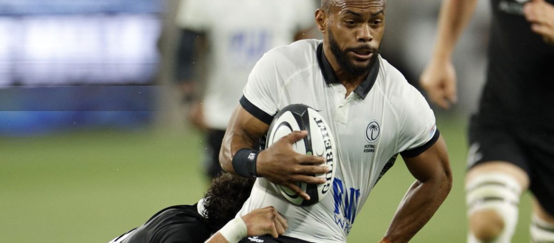 Fijian Waisea Nayacalevu is tackled with the rugby ball in his hands.