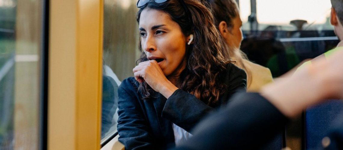 A woman stifles a yawn as she looks out of the window during her commute