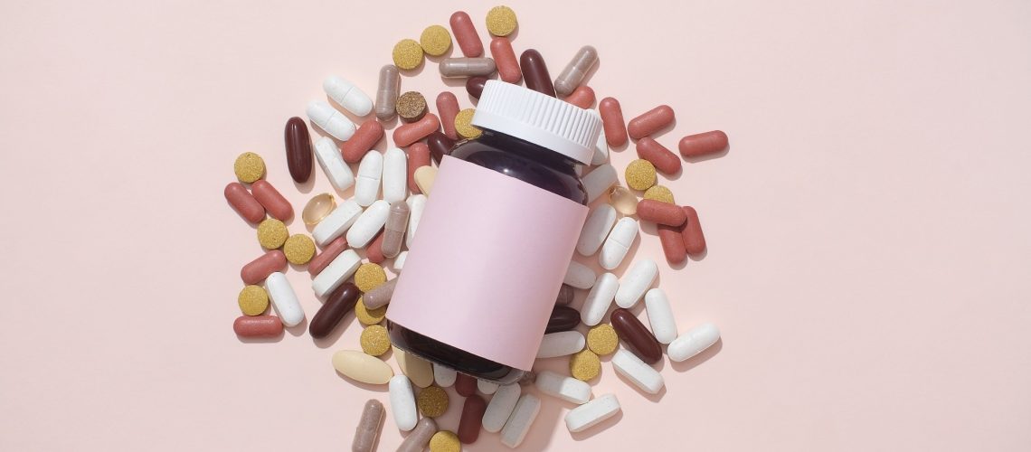 Pills of different colors and shapes are mixed.